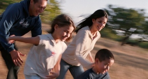 Family in park running in field